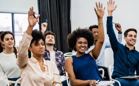 Group of young people sitting on conference together.